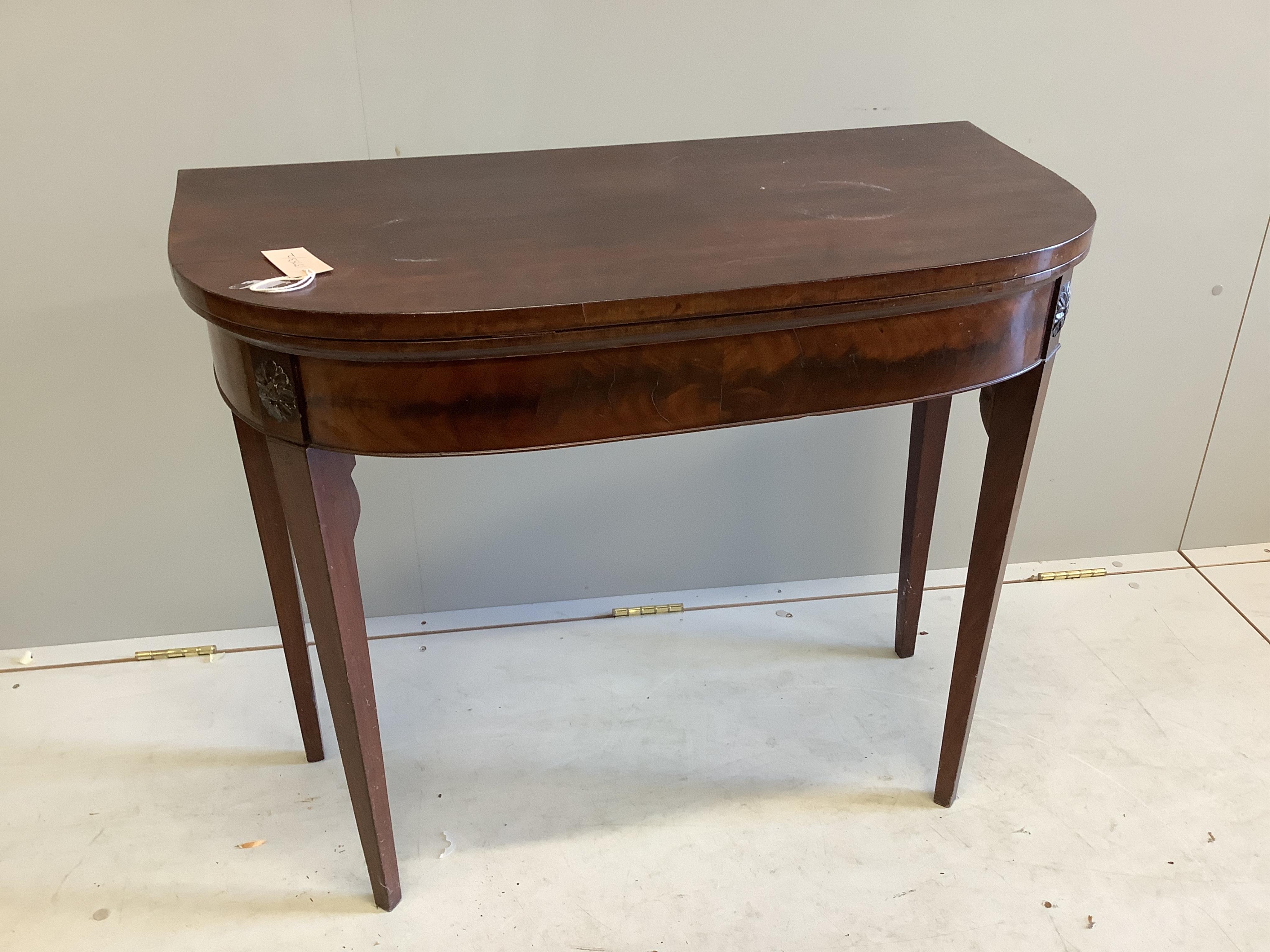 A George III mahogany D shaped folding card table, on square tapering legs, width 86cm, depth 42cm, height 73cm. Condition - poor